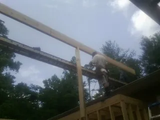 Carpenter setting a ridge beam over a new addition frame — Ice Dam Removal by Roofing Brothers in Benicia