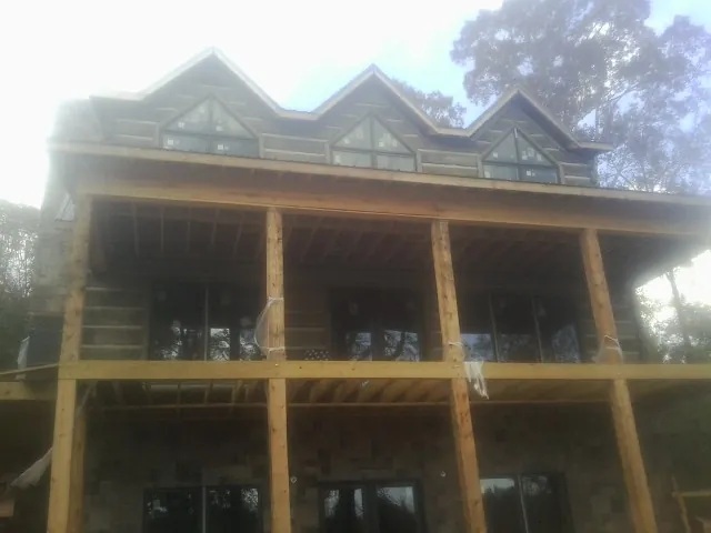 Dormers and porch framing on a large log home under construction — Roof Coating work by our crew in Benicia